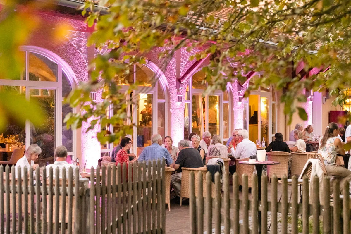 Gäste auf der begrünten Terrasse vor dem Steinebacher Bahnhof